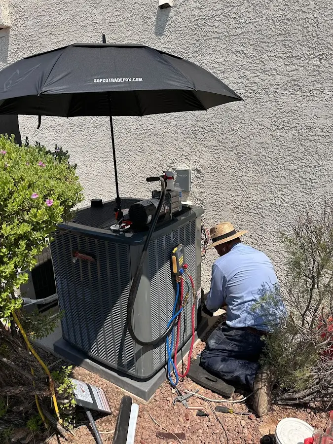 HVAC technician performing outdoor AC maintenance in Fayetteville